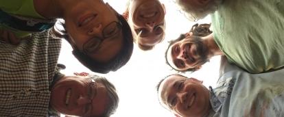 A group of older adults completing childcare volunteer work in Nepal, take a photo at their placement. A group of volunteers over 50 doing childcare volunteering in Nepal, take a photo outside their placement.